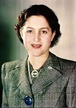 Photographie d'une femme portant un tailleur gris.