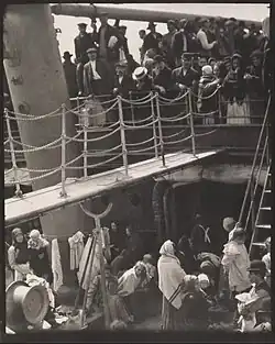 photo sépia d'une passerelle entre un bateau et un quai, en présence de la foule