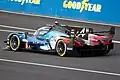 Photo de l'arrière d'une voiture de course bleue et noire sur le circuit du Mans.