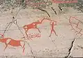 Homme utilisant une sorte d'outil en lien avec un élan, ayant porté à diverses interprétations telle qu'une scène de chasse ou un lien entre un chaman et animal.