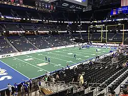 Vue de loin du terrain de l'Amalie Arena avec quelques joueurs. Public clairsemé dans les tribunes.