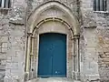 Tore garni d'anneaux entourant la porte du XIIIe siècle de l'église d'Amblie (Calvados).