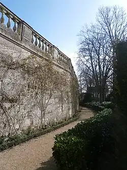Vue d'un mur courbe surmonté d'une balustrade.