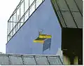 … là, telle qu'elle apparaît de l'autre côté du petit bâtiment sur la droite, révélant de ce point d'observation un échafaudage planté dans le mur, deux planches, un pot de peinture oublié là-haut…