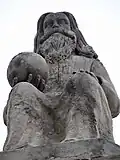 Au sommet du fronton, la statue de Dieu le Père, un globe dans sa main droite.