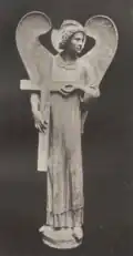Photographie d'un ange portant une croix.