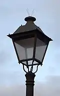 Lanterne classique à base carréemuni de pics anti-oiseauxposée sur un candélabre simpleEspagne