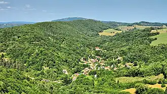 La combe des Mercureaux sur la rive « sauvage » et plus préservée du Doubs, avec en arrière-plan l'antenne-relais de Montfaucon.