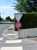 Panneau B2c placé à l'intersection, avec le panneau de cédez-le-passage