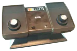Photo d'une console de salon Pong, avec deux paddles incrustés sur la machine.