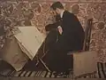 Le peintre Auguste Donnay consultant ses dessins.
