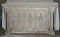 Sur le bas relief du maître autel sont représentés (de gauche à droite) : saint Matthieu, le Bon Pasteur et saint Jean l'évangéliste ?
