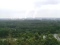 Photographie en couleurs représentant les panaches de vapeur d'une centrale nucléaire au loin.