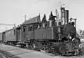 La locomotive-tender type Mallet B.L.E.A.G. 5 bis 8 (de) dans une gare de Karlsruhe, Allemagne. Mars 1958.