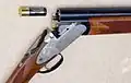 Sûreté de type bouton coulissant sur un fusil de chasse (à gauche).
