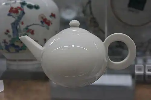 Une théière blanche de Dehua, ca. 1690-1720. Le socle est inscrit au nom de l' empereur Xuande, qui régna de 1426 à 1435, plus de 250 ans avant la fabrication de la théière. L'utilisation de marques de règne antérieures a une longue histoire en Chine, au grand dam des chercheurs modernes, et était destinée à indiquer le respect plutôt que de tromper. La conception géométrique audacieux de la théière anticipe les formes du modernisme européen de plus de deux siècles.