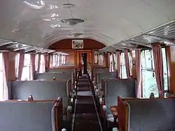 Voiture à couloir central de troisième classe en configuration plus luxueuse (2+1 places).