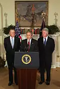 George W. Bush faisant une annonce entouré des deux anciens présidents, Bush père et Clinton, pour une levée de fonds au profit des victimes du tsunami du Sud-Est asiatique. En arrière-plan, Rough Rider, le portrait équestre de Theodore Roosevelt.
