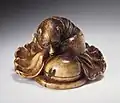 Netsuke représentant un tanuki-bōzu, probablement le moine Shukaku de la légende Bunbuku Chagama, deuxième moitié du XIXème siècle.