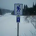 Un panneau de signalisation blanc montrant un randonneur et l'inscription SIA/IAT