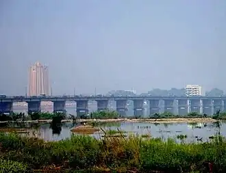 Vue depuis la rive sud du fleuve Niger, en direction du nord, avec le pont des Martyrs, et en arrière-plan la tour de la BCEAO.