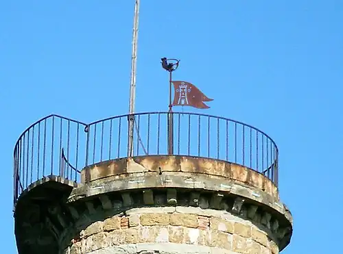 Girouette au sommet de la tour. Au-dessus, l'emblème de la famille Torrigiani est visible.