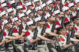 Légionnaires, en tenue de défilé, portant un fusil d'assaut FAMAS.