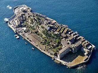 Photographie aérienne représentant l’île de Hashima entourée par l’océan
