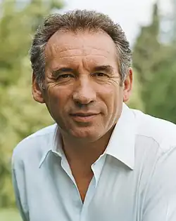 Photographie en couleurs d'un homme souriant.