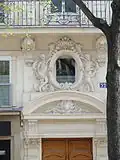 No&nbsp;52 : encadrement sculpté de l'oculus au-dessus de la porte d'entrée.