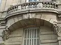 No&nbsp;64 : détail du balcon, montrant la date de construction de l'immeuble.