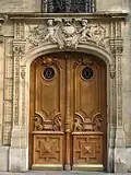 No&nbsp;92 : porte en bois sculpté, avec sphinx ailés. Dessus de porte avec angelots.