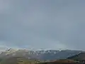 L'extrémité méridionale de la chaîne de Belledonne vue depuis Grenoble avec de gauche à droite la Grande Lance de Domène, le Grand Colon et la Croix de Chamrousse coiffée des gares d'arrivée des remontées mécaniques.