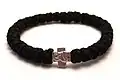 Tchotki en bracelet avec 33 nœuds et une croix.