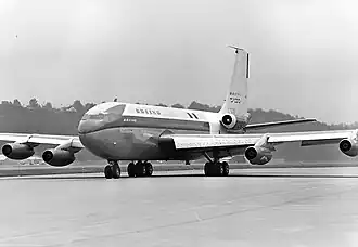 Photo en noir et blanc, vue de trois quarts-avant d'un avion roulant sur une piste de décollage ou d'atterrissage, mettant en évidence ses cinq turboréacteurs ; quatre réacteurs sont présents sous la voilure, deux sous chaque aile, et le cinquième est installé sur le côté du fuselage.