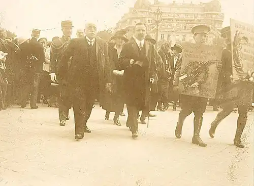 Photographie de personnes devant un bâtiment.