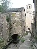 Bâtisse couverte en lauze surplombant le ru.