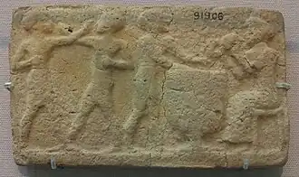 Deux hommes boxant et deux musiciens jouant du tambour et du claquoir. Début du IIe&nbsp;millénaire&nbsp;av. J.-C. Larsa, British Museum.