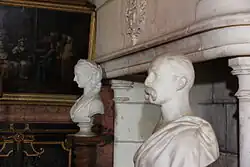 Photogtaphie en couleurs d'une sculpture représentant au premier plan le buste d'un personnage vêtu d'une toge romaine.