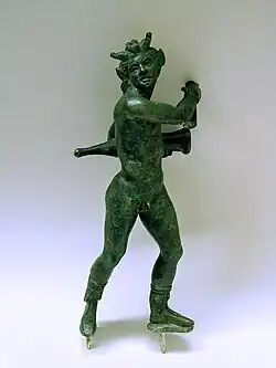 Statue d'un homme à tête cornue portant une amphore sous le bras gauche partiellement dissimulée derrière lui.