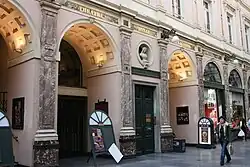 Photographie d'une galerie couverte avec des arcades.