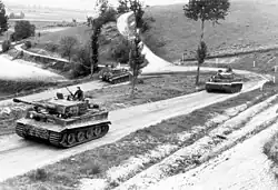 Photo montrant trois blindés allemands sur une route de campagne.