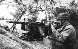 Fallschirmjäger en position dans un bosquet, avec une MG-42