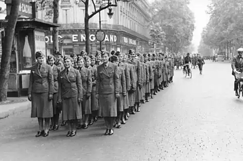 Au début de l'occupation allemande, en août 1940, auxiliaires féminines de transmissions défilant sur le boulevard des Capucines (en arrière-plan, le magasin Old England, une des enseignes emblématiques de l'artère, de 1867 à sa disparition en mars 2012).