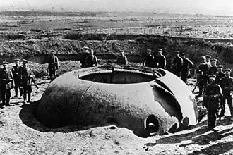 Soldats allemands posant autour de la tourelle Mougin du fort de Boussois (lors du siège de Maubeuge), décalottée en 1914 par les obus de 210&nbsp;mm.