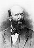 Dessin en noir et blanc d'un homme chauve en costume à la barbe fournie.