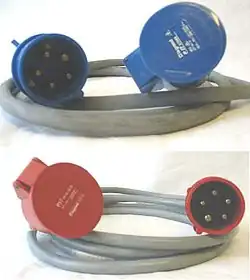 Deux câbles avec chacun une prise 3P+N+T à une extrémité et un socle de même type à l'autre extrémité. Le câble de dessus a des connecteurs bleus, celui de dessous a des connecteurs rouges.