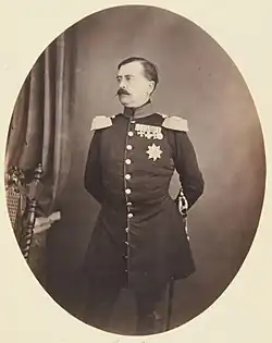 portrait en pied, de trois-quarts, de Charles-Antoine, revêtu d'un uniforme à épaulettes et arborant des médailles, regarde vers sa gauche, le visage à l'expression neutre porte une moustache foncée aux pointes effilées
