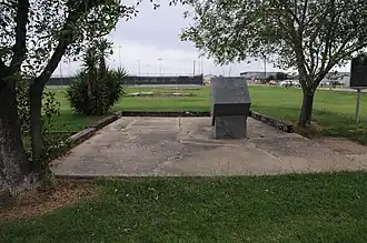 Vue d'un bloc de pierre taillée, en bordure d'un stade.