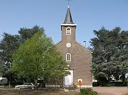 Édifice religieux en brique avec des arbres.
